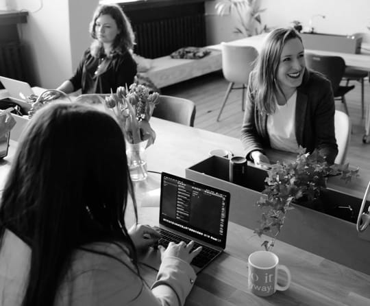 Women working on macbooks in an office