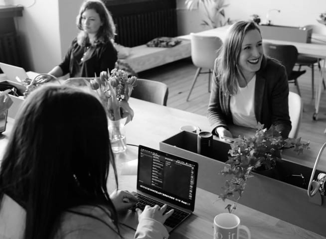 Women working on macbooks in an office